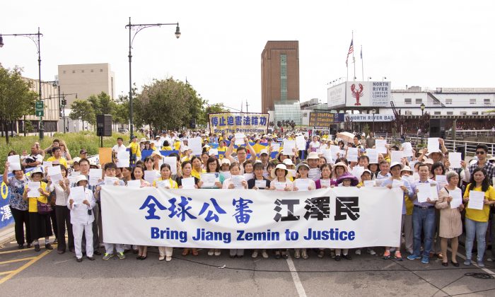 I praticanti del Falun Gong con le loro denunce penali in una manifestazione davanti all'ambasciata cinese di New York, il 3 luglio 2015. Queste persone si sono riunite per sostenere lo sforzo globale di citare in giudizio Jiang Zemin. (Larry Dye/Epoch Times)