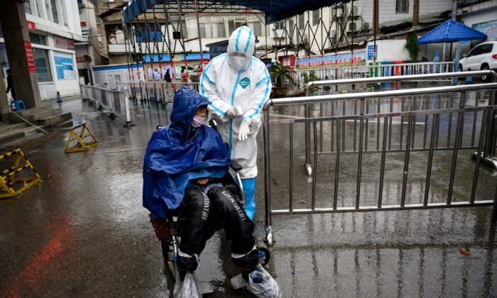 Un operatore sanitario assiste un uomo in cerca di cure, presso una clinica per la febbre all'ospedale Huanggang Zhongxin di Huanggang, Hubei, il 27 marzo 2020. (Noel CelisAFP tramite Getty Images)