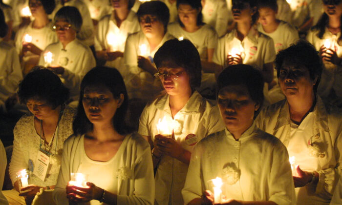 I praticanti del Falun Gong tengono una veglia a lume di candela per rendere omaggio alla vita di coloro che in Cina sono stati picchiati e torturati a morte, a Washington, Dc il 19 luglio 2001. (Alex Wong/Getty Images)