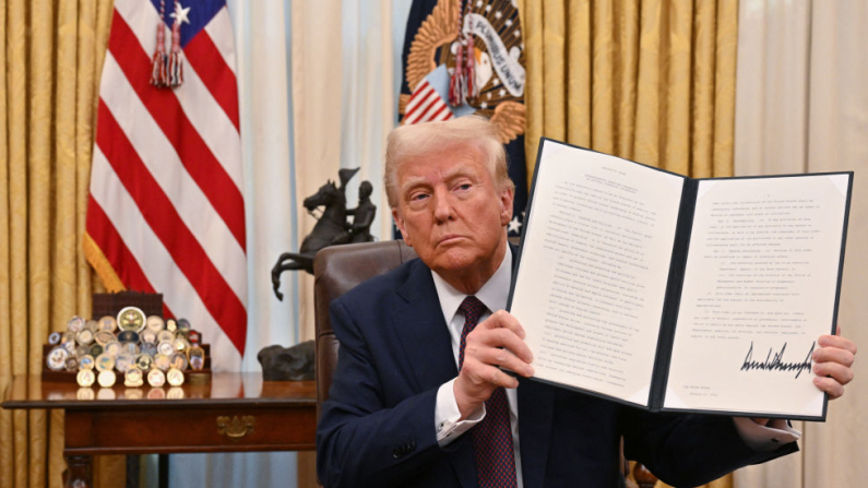 Il presidente degli Stati Uniti Donald Trump mostra  un ordine esecutivo appena firmato nell'Ufficio Ovale della Casa Bianca (Foto: ROBERTO SCHMIDT/AFP via Getty Images).