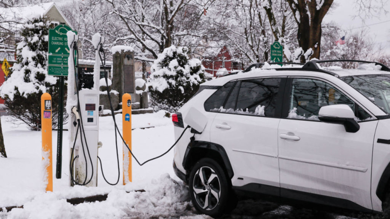 Auto elettrica in carica sotto la neve (foto  KENA BETANCUR/AFP via Getty Images.