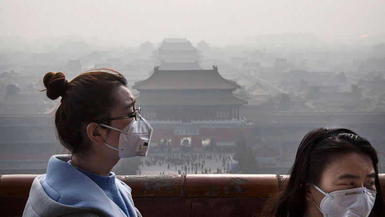 Donne cinesi indossano la mascherina nell'aria irrespirabile di Pechino. Foto scattata nel novembre 2015 (Kevin Frayer/Getty Images)