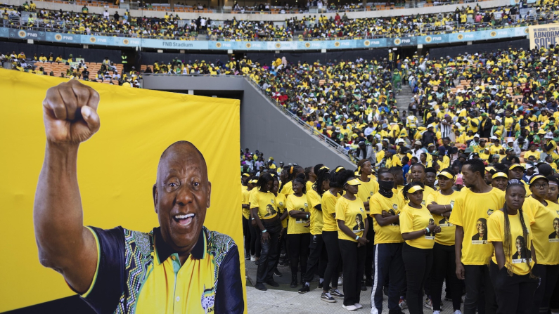 Artisti accanto a uno striscione con l'immagine del presidente sudafricano Cyril Ramaphosa durante il comizio finale per le elezioni dell'African National Congress, Johannesburg, 25 maggio 2024 (foto EPA/KIM LUDBROOK via Ansa).